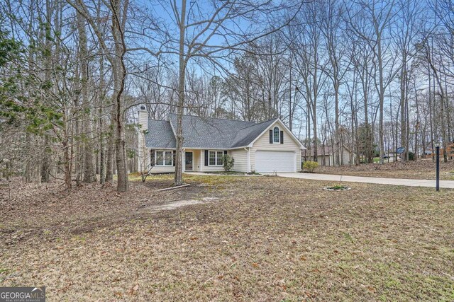 view of front of home featuring concrete driveway and a chimney