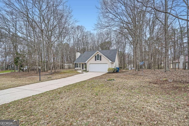 view of front of house featuring a garage, driveway, a front lawn, and a chimney