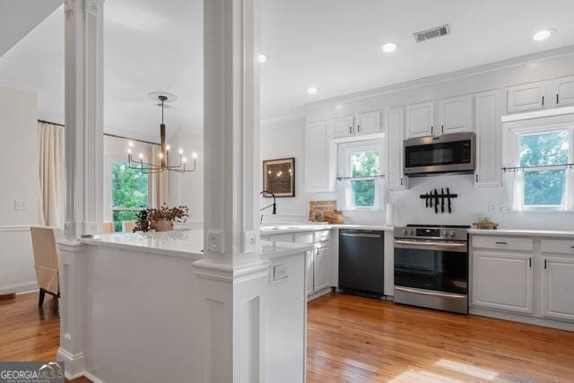 kitchen with light wood-style floors, visible vents, stainless steel appliances, and light countertops