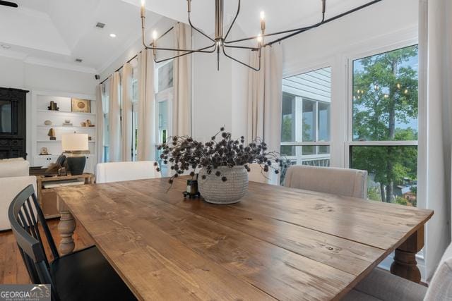 dining room with built in features, ornamental molding, a notable chandelier, and recessed lighting