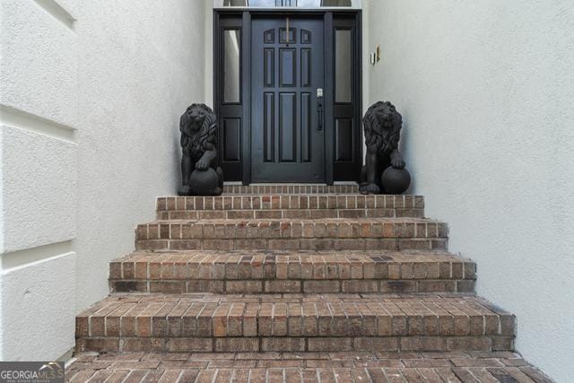 entrance to property featuring stucco siding