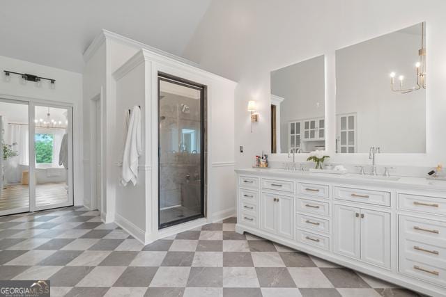 full bath featuring a sink, double vanity, a notable chandelier, and tile patterned floors