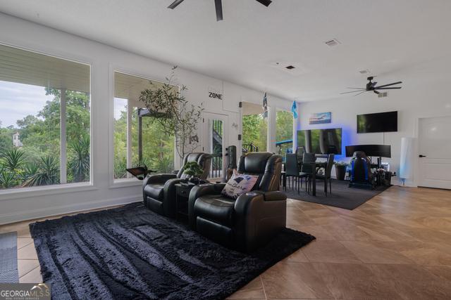 tiled living room featuring a ceiling fan