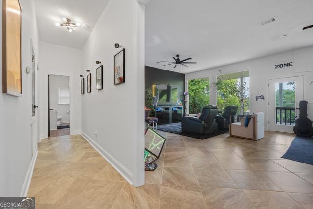 hallway with baseboards and visible vents