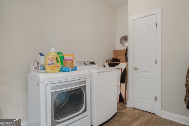 laundry room featuring baseboards, laundry area, light tile patterned floors, and washer and dryer