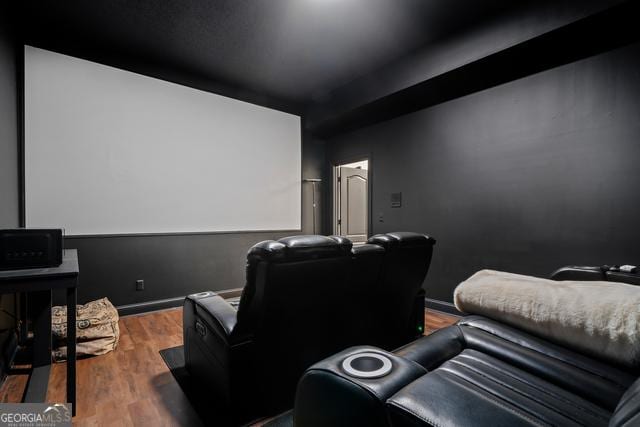 home theater featuring baseboards and wood finished floors