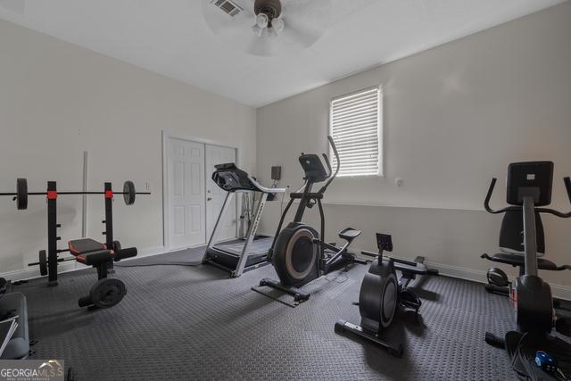 workout area featuring visible vents, baseboards, and a ceiling fan