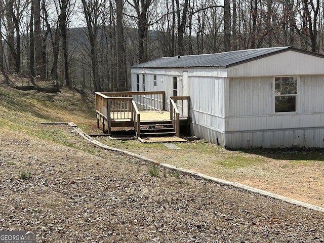 exterior space with metal roof and a wooden deck