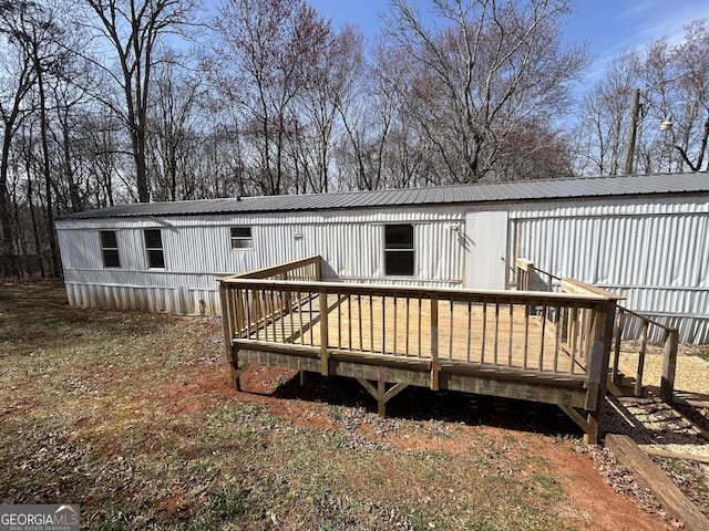 back of property featuring a deck and metal roof