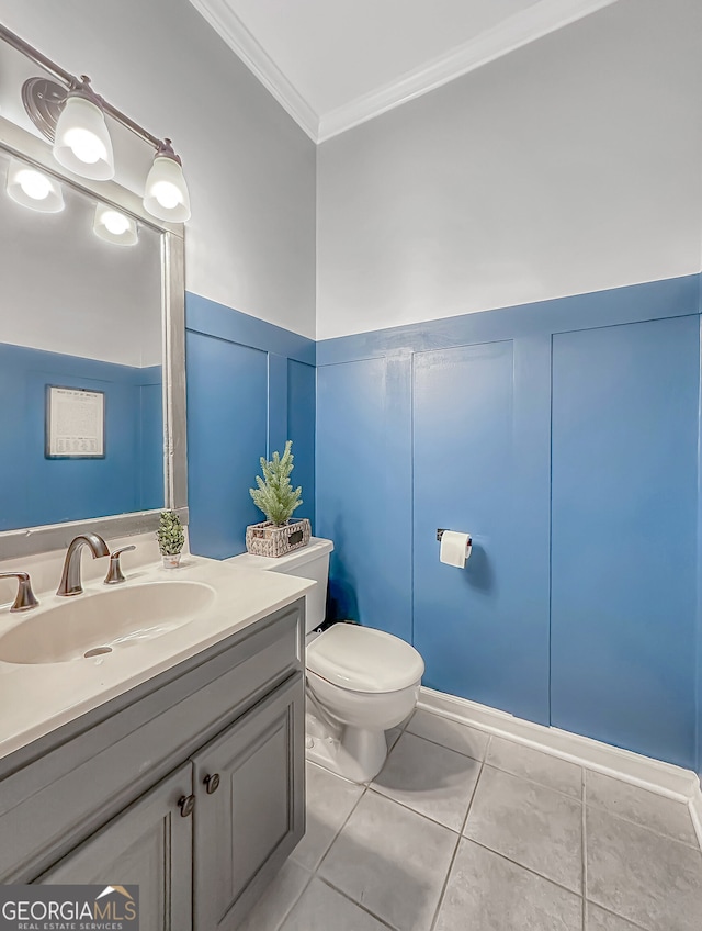 half bath featuring wainscoting, toilet, tile patterned floors, crown molding, and vanity