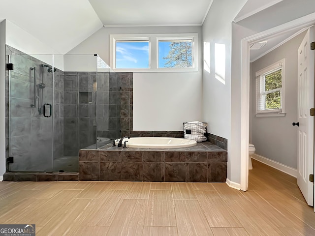 full bathroom featuring a stall shower, toilet, lofted ceiling, crown molding, and a bath