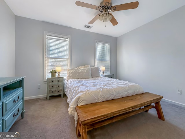 bedroom featuring baseboards, multiple windows, visible vents, and light colored carpet