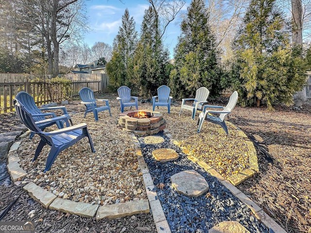 view of yard with fence and a fire pit