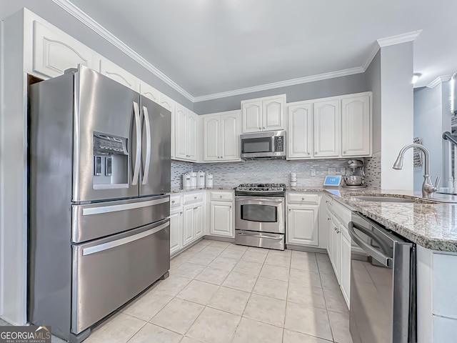 kitchen with appliances with stainless steel finishes, a sink, white cabinets, and crown molding