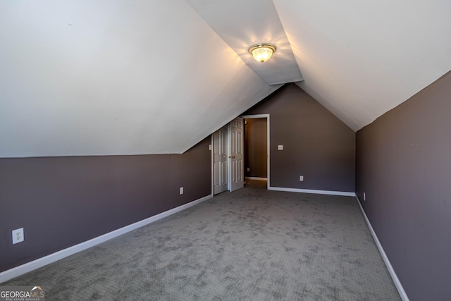 additional living space with vaulted ceiling, carpet floors, and baseboards