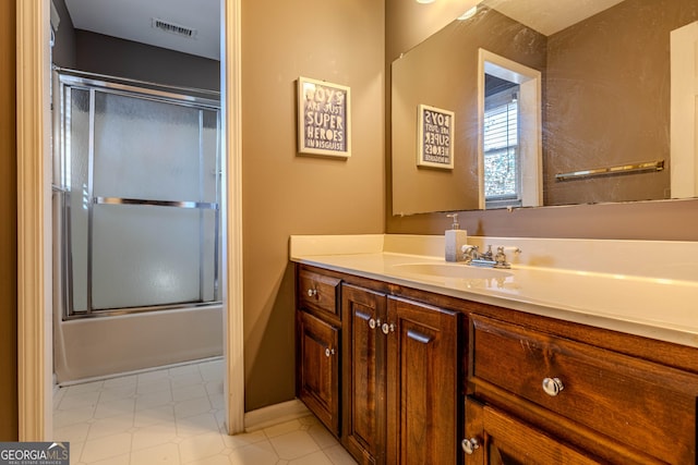 full bath featuring bath / shower combo with glass door, vanity, and visible vents