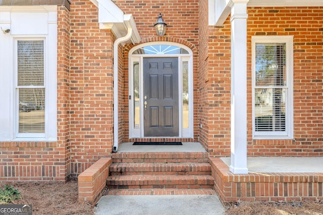 entrance to property featuring brick siding