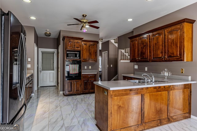 kitchen with marble finish floor, a peninsula, appliances with stainless steel finishes, and a sink