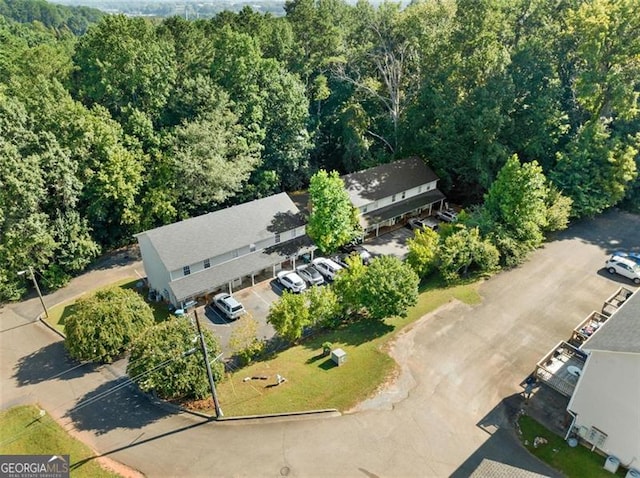 birds eye view of property featuring a forest view