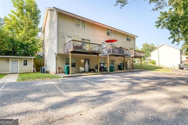 rear view of property featuring uncovered parking and central AC unit