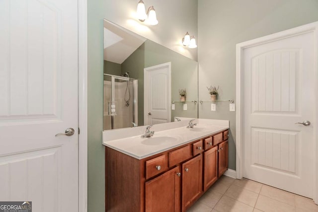 bathroom with double vanity, a stall shower, a sink, and tile patterned floors