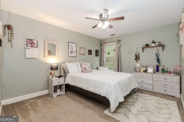carpeted bedroom with visible vents, baseboards, and a ceiling fan