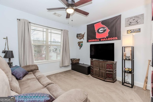 carpeted living room with baseboards, visible vents, and a ceiling fan