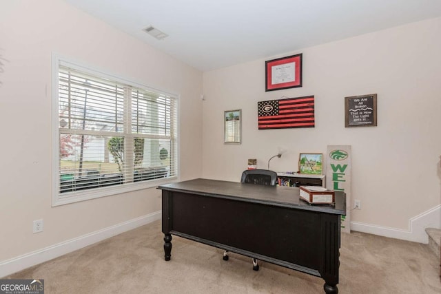 office with baseboards, visible vents, and light colored carpet