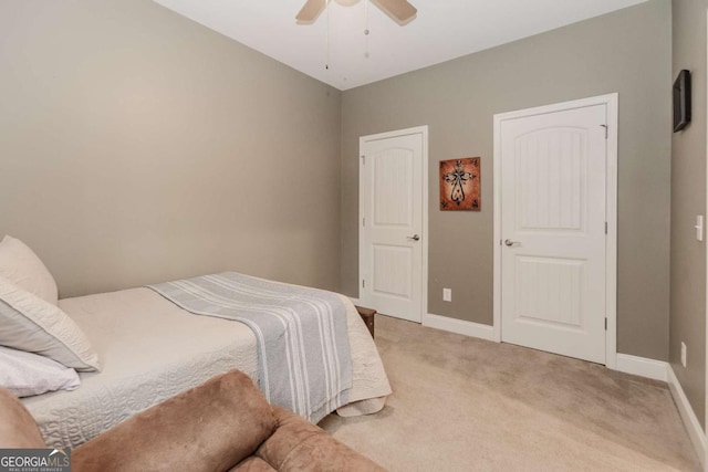 bedroom featuring light carpet, a ceiling fan, and baseboards