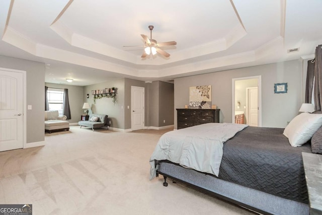 carpeted bedroom featuring a raised ceiling, visible vents, ornamental molding, connected bathroom, and baseboards