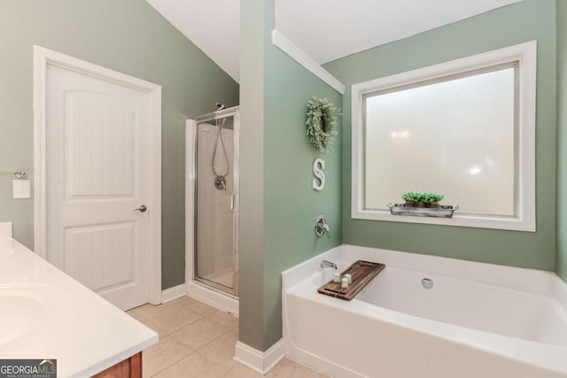 bathroom with baseboards, a shower stall, double vanity, tile patterned floors, and a garden tub