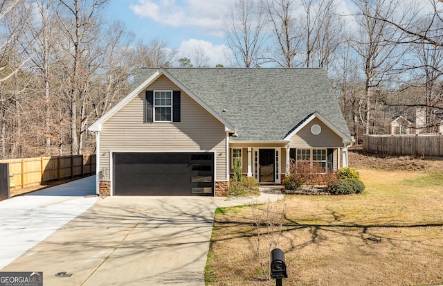 traditional-style house featuring concrete driveway, a shingled roof, an attached garage, and fence