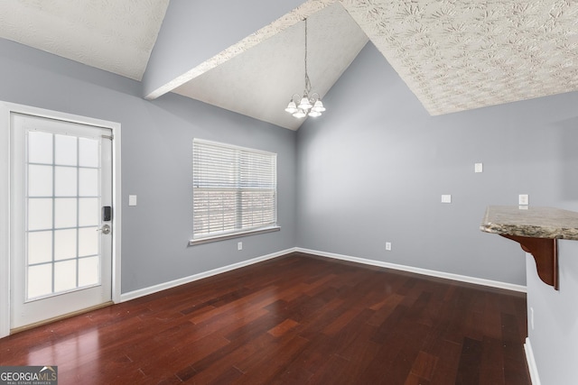 unfurnished dining area with a textured ceiling, a chandelier, wood finished floors, and baseboards