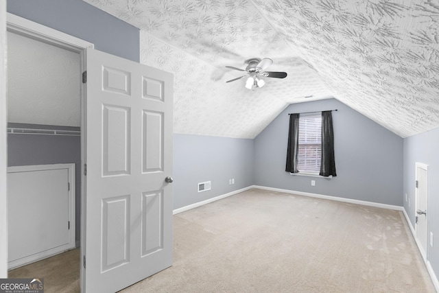 bonus room with visible vents, vaulted ceiling, a textured ceiling, and carpet flooring