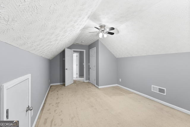 additional living space with a textured ceiling, carpet, visible vents, and baseboards