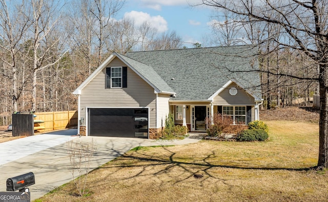 traditional-style house with a shingled roof, concrete driveway, stone siding, fence, and a front yard