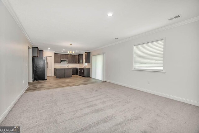 137 Walnut Way, Kingsland, GA 31548 - unfurnished living room with a chandelier, light carpet, ornamental molding, baseboards, and recessed lighting