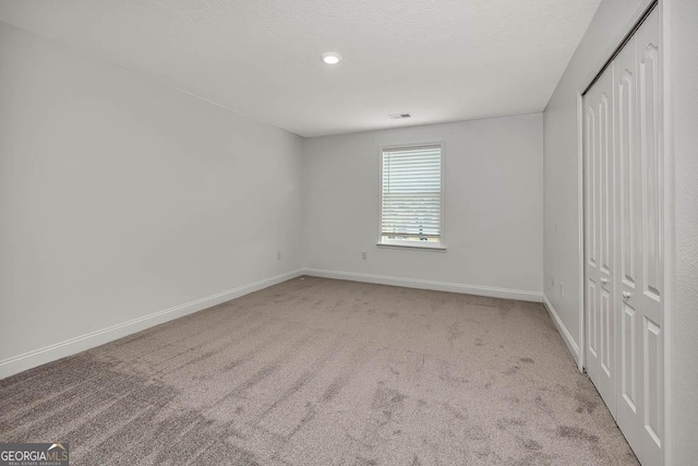 137 Walnut Way, Kingsland, GA 31548 - unfurnished bedroom with light colored carpet, baseboards, and a closet