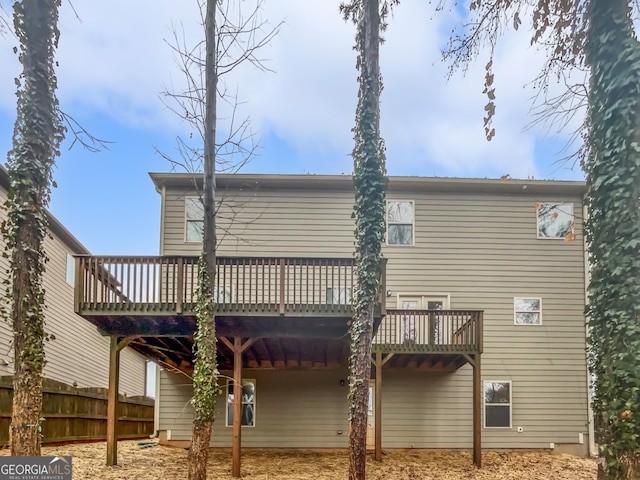 rear view of property featuring fence and a deck