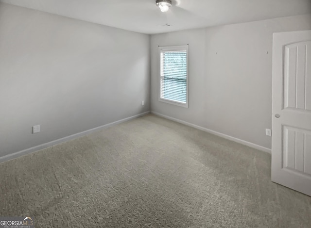 spare room with baseboards and carpet flooring