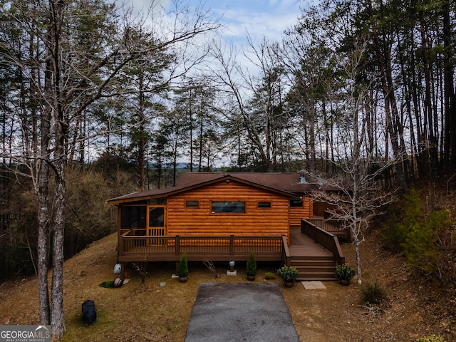 log home featuring a sunroom, a deck, and log veneer siding