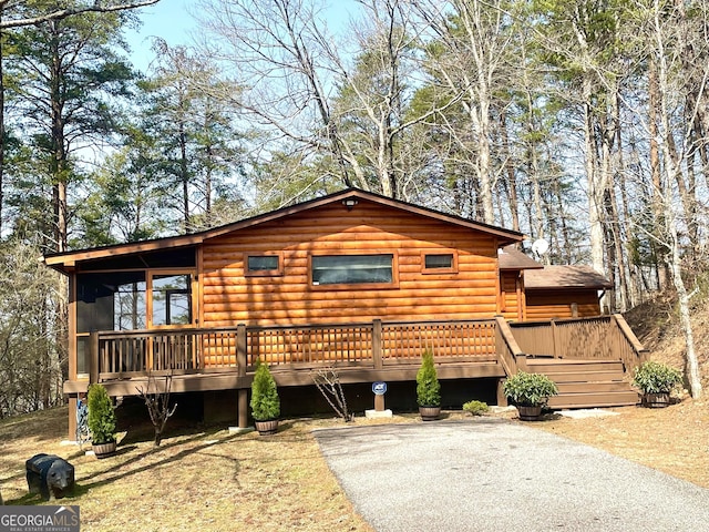 view of front of home with a wooden deck and a sunroom