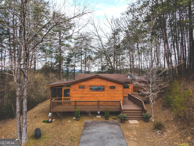 cabin featuring a wooden deck and a sunroom