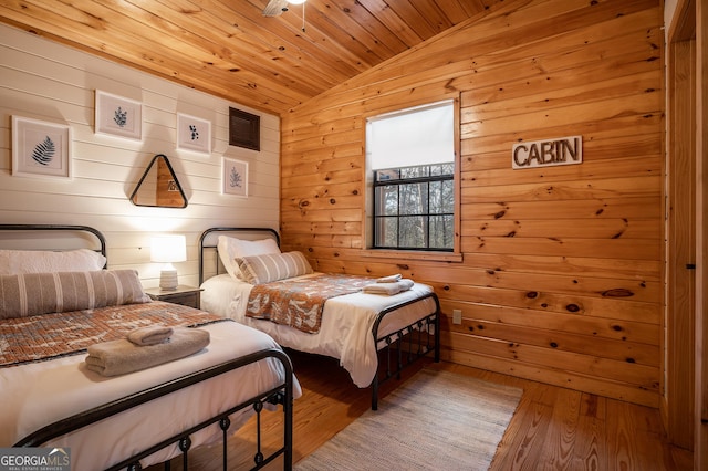 bedroom with wooden ceiling, wood-type flooring, vaulted ceiling, and wooden walls