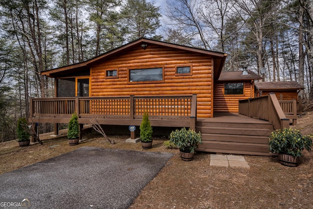 view of front facade featuring a deck and faux log siding