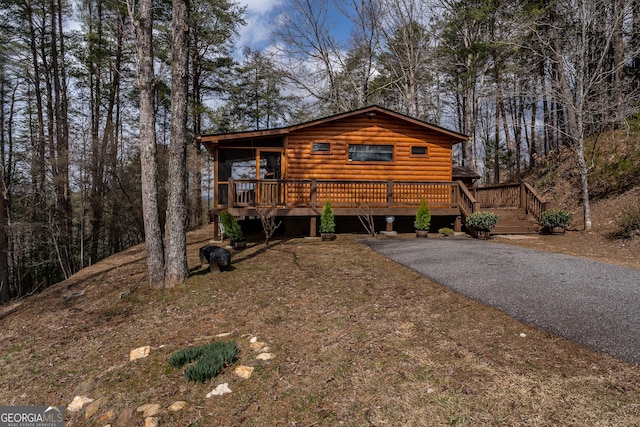 view of front of property featuring aphalt driveway and a deck