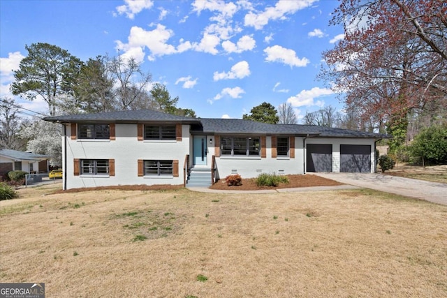 tri-level home with crawl space, an attached garage, driveway, and a front yard