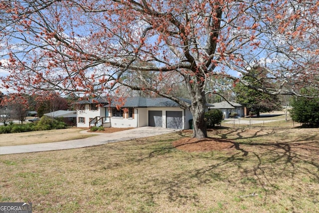 view of front of home with a front yard, concrete driveway, an attached garage, and fence