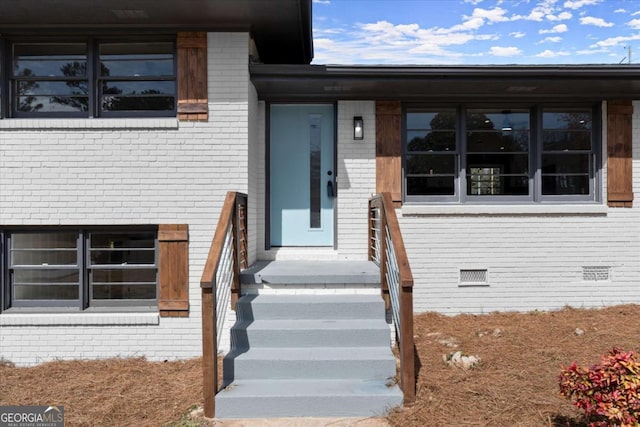 entrance to property with brick siding and crawl space