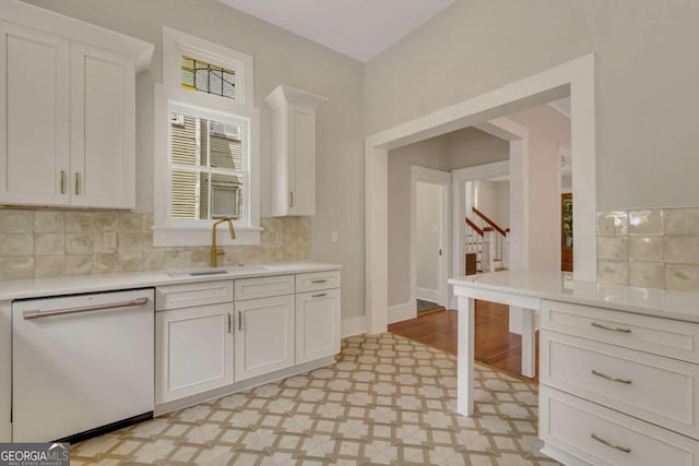 kitchen with a sink, light floors, light countertops, and dishwasher